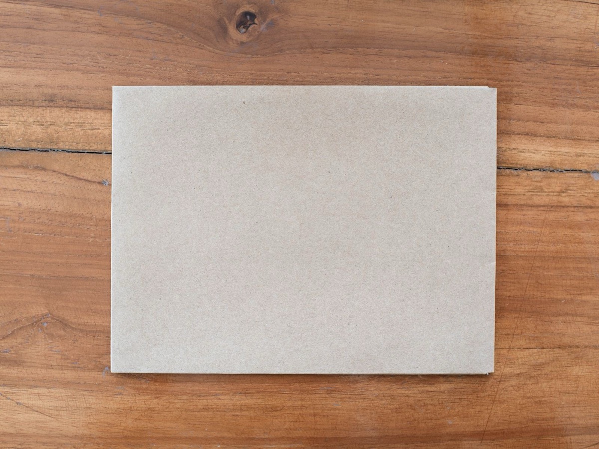 A plain brown envelope lying on a wooden table